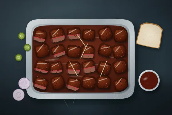 Glossy chuck roast burnt ends in a foil pan with toothpicks, pickles, onions and white bread